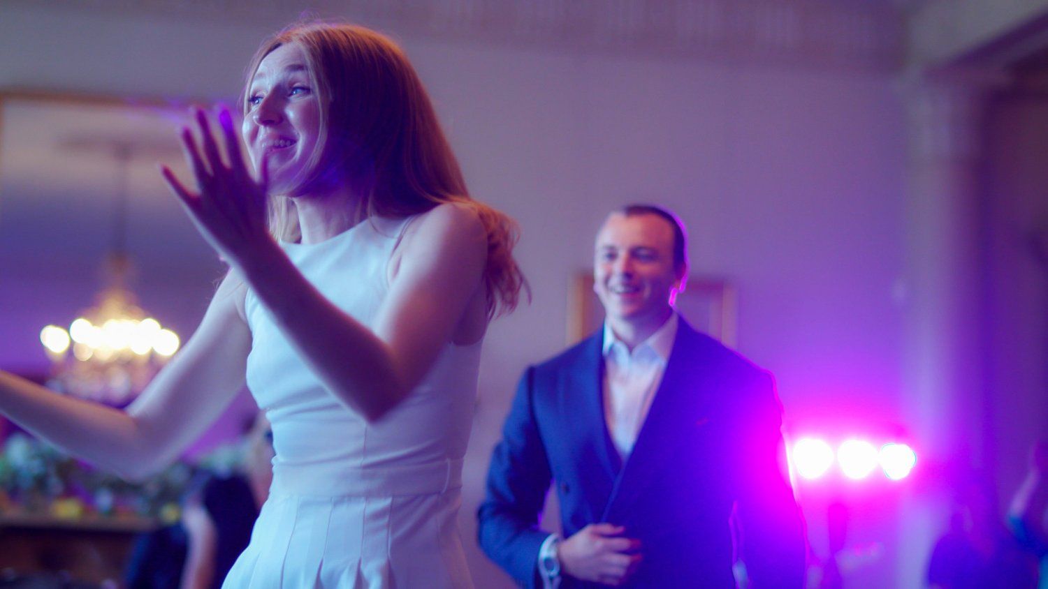Bride dancing under reception lights