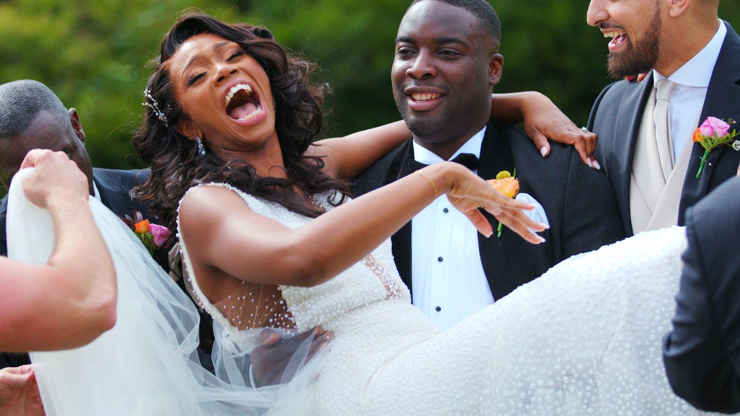 Bride laughing with groomsmen outdoors