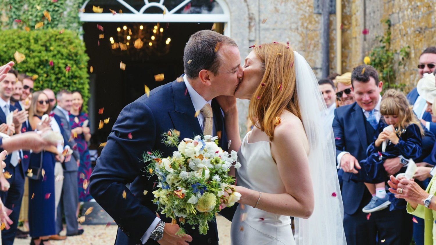 Bride and groom kissing in confetti